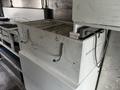 White metal storage box with handles inside a step van workshop featuring a cluttered interior