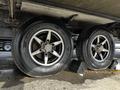 Close-up of two Goodyear tires mounted on alloy wheels of a 2021 Grand Design Recreational 311BHS trailer with a support block beneath them