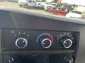 Dashboard controls of a 2013 Chevrolet Express featuring a fan speed knob a temperature dial and audio system controls