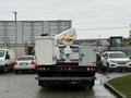 A 2006 Ford F-450 truck equipped with a raised aerial lift and safety lights mounted on the back