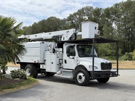 A 2020 Freightliner M2 utility truck equipped with a bucket lift and storage compartments on the side