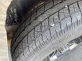 A close-up view of a tire showing its tread pattern on a 2022 Discovery DMA61 14 foot cargo trailer ramp gate