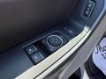 Close-up of a control panel in a 2023 Ford F-550 featuring buttons for window and door adjustments along with a dial for headlight settings