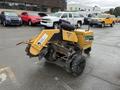 A yellow 2014 Vermeer Corporation Sweep Stump Cutter with rugged tires and a front blade attachment designed for grinding tree stumps