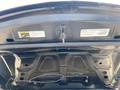 The underside of the hood of a 2019 Dodge Charger showing the latch mechanism and labels attached to the inner surface