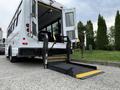 A 2015 Chevrolet Express with a wheelchair lift extended in the foreground