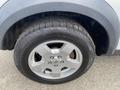A close-up view of a silver wheel and tire from a 2006 Land Rover LR3 showcasing a five-spoke alloy rim and a rugged tread pattern on the tire