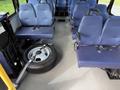 A 2020 Chevrolet Express interior with blue fabric seats and a spare tire on the floor next to the seats