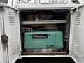 A turquoise Onan Commercial Mobile Power generator stored inside a white utility vehicle compartment