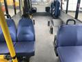 Interior view of a 2016 Chevrolet Express showing several blue seats and a spacious aisle area with no visible passengers