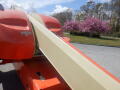 A 2008 JLG Boom Lift with a long extending arm and orange body positioned prominently in the foreground