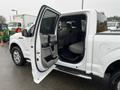 White 2016 Ford F-150 with front door open revealing the interior seating and dashboard