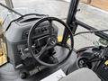 A 2011 John Deere 310SJ 4x4 Wheel Loader Extended Hoe 4 in 1 featuring a black steering wheel and control panel with various levers and buttons