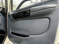 The interior door panel of a 2006 Hino 155 featuring a sleek gray design with a door handle and a speaker grille