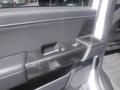 A close-up of the door panel of a 2022 Ford F-150 showing the armrest and integrated controls for windows and locks