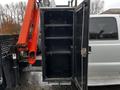 A 2014 Ford F-550 with an open utility box revealing three shelves inside