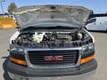 A 2016 GMC Savana with its hood open revealing the engine compartment showcasing various engine components and wiring