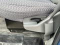 The image shows the side of a 2010 Ford Econoline seat featuring a gray fabric pattern and a lever for adjusting the seat position