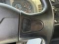 Close-up of the steering wheel of a 2009 International 7500 with a textured black surface and a small control panel on the side