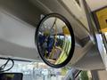 A round rearview mirror reflecting the interior of a 2017 Chevrolet Express with blue seats and yellow accents
