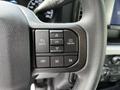 Close-up of the steering wheel controls in a 2024 Ford F-550 featuring buttons for back menu and phone functions