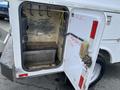 A 2015 Ford F-550 service truck with an open utility compartment revealing shelves and hooks for tools and equipment