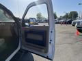 A 2014 Ford F-350 SD with the driver's side door open showing the interior door panel and handle