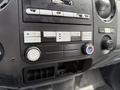 Close-up of the dashboard controls of a 2013 Ford F-550 featuring buttons for audio climate and air conditioning settings