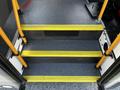 Steps with yellow safety markings leading into a vehicle with a pole on the right side
