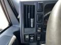 Control panel of a 2016 Isuzu NPR showing buttons for various functions and an air vent with a spring inside
