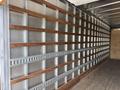 A 2022 International MV607 truck with a wooden wall and metal shelving system inside the cargo area