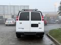 A white 2016 GMC Savana van is shown from the rear with a blank license plate and a roof rack visible