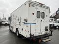 A white 2012 Workhorse W62 commercial vehicle with a boxy design featuring multiple access doors and a blue stripe along the side