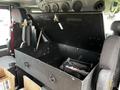 An open storage compartment in a Spartan Gladiator showing a black interior and a supporting hinge