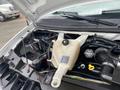 The engine compartment of a 2014 Chevrolet Express showing the coolant reservoir and various engine components with visible wiring and hoses