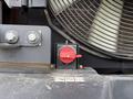 Close-up of a red control knob on a Doosan DL300-5 machine with a fan and metallic components in the background