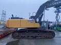 A yellow 2014 John Deere 350G excavator with a black arm and tracks positioned on a trailer