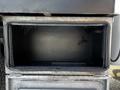 An empty metal storage compartment with a textured surface mounted on a vehicle