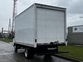 A white 2021 Mitsubishi FE box truck viewed from the rear showing its large cargo area and rear loading dock