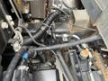Close-up view of the engine compartment of a 2008 Mitsubishi Fuso FE180 showing various wires and components including hoses and an electrical connector