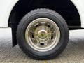 A chrome wheel with five circular bolt holes and a rugged tire on a 2011 Ford F-550