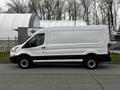 A white 2017 Ford Transit van viewed from the side with a black stripe along the bottom and no visible markings on the exterior