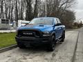 A blue 2021 RAM 1500 Classic pickup truck with a black hood and front grille parked on a street