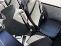Interior view of two dark leather seats with seatbelts in a 2022 Blue Bird Vision bus