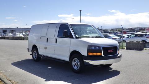 A white 2015 GMC Savana van with a black grille and standard wheels parked at an angle with its side doors closed