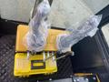 The interior controls of a 2024 AGT Industrial H13R Mini Excavator with two joystick levers wrapped in plastic on a yellow control box