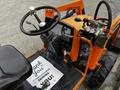 A 2001 Agco ST40 tractor featuring an orange body and a steering wheel with control levers and a dashboard displaying gauges and indicators