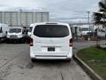 A white 2018 Mercedes-Benz Metris viewed from the rear displaying a sleek design with a prominent logo and large rear windows