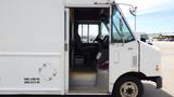 A 2011 Ford Econoline with a white exterior showing the driver's side door open and the interior visible including the driver's seat and dashboard