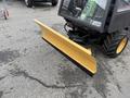 A yellow snow plow attachment mounted on the front of a 1994 John Deere F1145 tractor